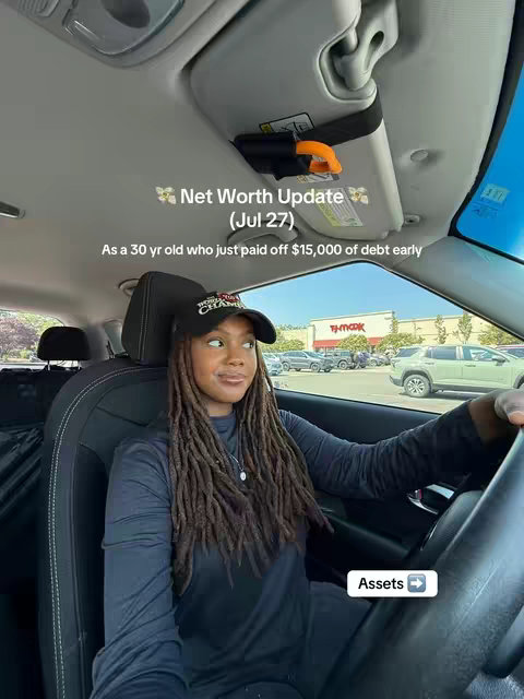 The image is a selfie taken from inside a car, showing a woman in the driver's seat. She has long locs, a black cap, and a dark outfit. The shot is framed from a slightly low angle, including the car's interior elements like the sun visor. Text overlays state the video's topic, date, and theme. The background outside the window includes a parking lot and a retail store.
