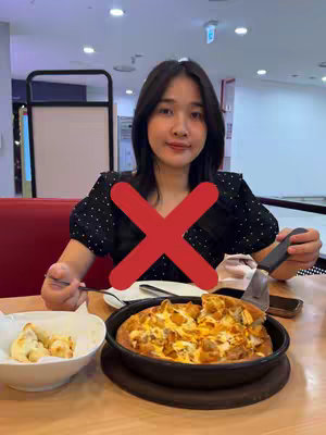 The cover image features a young woman seated at a table in what appears to be a restaurant. She is looking towards the camera with a neutral expression. A large red 'X' symbol is overlaid across her torso, suggesting disapproval or a negative action. On the table in front of her are a pizza, a bowl of breadsticks, and other dining items. The background is blurred but indicates a dining area.