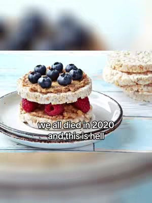 The cover image shows a round, layered dish on a plate, resembling a sandwich. The bottom layer appears to be a rice cake, topped with a blurred spread of peanut butter, and is filled with red raspberries on the bottom. Another identical rice cake lays on top as the second layer and is topped with several blueberries as the top layer.