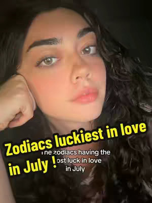 A selfie-style shot featuring a young woman with long, dark hair. She gazes directly at the camera, resting her head on her hand against her cheek. Positioned over the image is a text overlay with a yellow background and black text reading 'Zodiacs luckiest in love in July!'