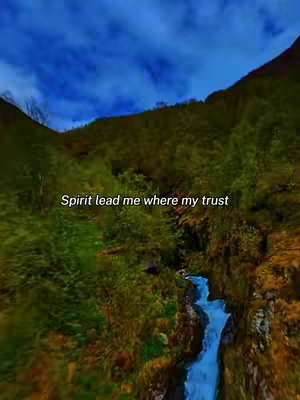 The image shows a landscape with a mountain and river with text overlayed. The scene features a bright blue sky with some clouds, green mountain and valley with a river cascading down. The text overlayed in the middle says: Spirit lead me where my trust.