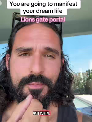 A close-up shot of a man with long dark hair, a full beard, and sunglasses perched on his head. He is looking at the camera with a serious expression. Text overlays are present at the top and bottom, with a background of a bright sky and foliage.