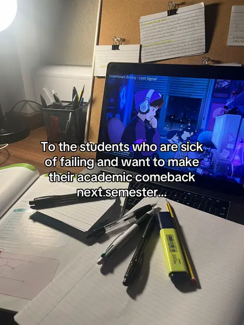 The cover image shows a desk with study materials. A laptop displays an animated image with the title "Downtown Binary - Lost Signal." In the foreground, there are pens, a highlighter, and notebooks. The overall composition is a close-up shot of a study space, lit by a desk lamp.