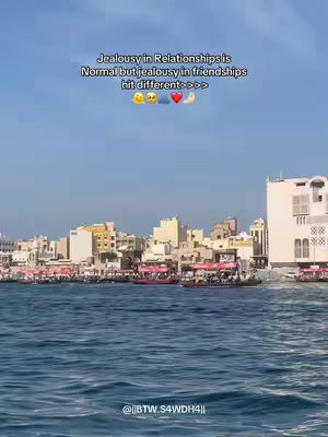 A scenic view featuring a body of water in the foreground with buildings along the shoreline in the background under a blue sky. A text overlay is present.