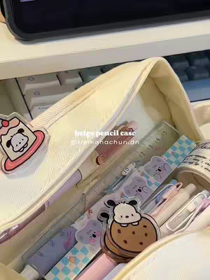 The cover image shows a beige pencil case open, filled with stationery items such as pens, pencils, rulers, and stickers featuring bear and dog characters. The lighting is natural, and the overall composition has a cluttered yet organized aesthetic.