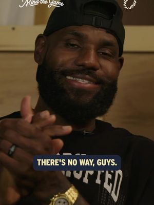 A close-up shot of LeBron James smiling and clapping. He's wearing a black cap and a black shirt, with a gold watch and a silver ring visible. A text overlay reads, "THERE'S NO WAY, GUYS." The background is a blurry, warm-toned setting.