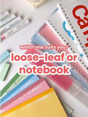 The image displays a selection of colorful stationery items, including various notebooks and packets of loose-leaf paper. They are stacked against each other and arranged on a white surface. The bright colors of the different notebooks and loose-leaf paper create a visually appealing arrangement.