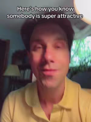 The cover image features a man in a yellow shirt, looking at the camera. Text overlay at the top reads, 'Here's how you know somebody is super attractive.' The background is blurred, suggesting an indoor setting.