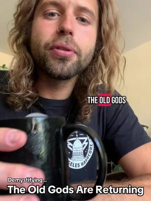 A man with long wavy blonde hair and a beard appears to be speaking to the camera, holding a black mug with a logo. Overlayed text reads: "THE OLD GODS." Additional text at the bottom states: "Demystifying… The Old Gods Are Returning".
