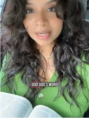A woman with long, dark, curly hair looks directly at the camera. She's wearing a green sweater and a gold necklace. Her mouth is open slightly, and she appears to be speaking. In the foreground a book open with text facing the camera, and the bottom layer of the image has the text overlay 'GOD GOD'S WORD'. The overall composition is well-lit and focused on the woman's face.
