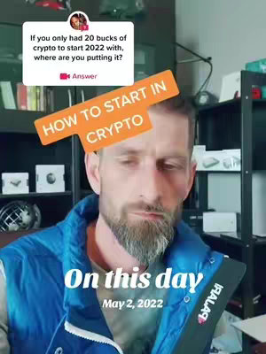 A man with a beard is centered. Overlay text includes a question about where '20 bucks of crypto' would be put. Additional text states 'On this day, May 2, 2022'. The background shows a shelf, and some books.