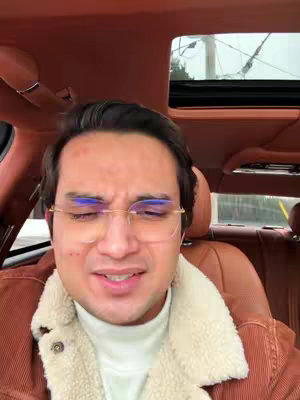 The cover image shows a man inside a car. He is wearing glasses and a brown jacket with a white fur collar. He has a slightly strained facial expression. The car interior is visible, with brown leather seating and a sunroof.
