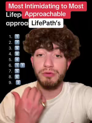 The cover image is a selfie-style shot of a young man with short, curly brown hair and a trimmed beard, set against a plain black background. He is wearing a plain white t-shirt. Above him at the top of the image are some words over a red rectangular band. Below, in a white banner, is the text LifePath's. Arranged below this are the numbers 1-9 in white with numbered columns. 