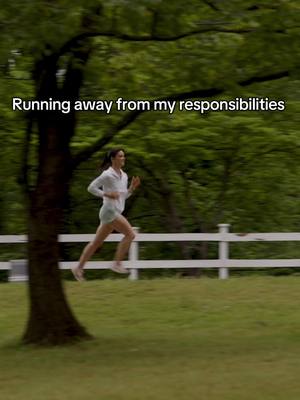 A woman running in a grassy field toward the right, with a tree on the left and a white fence in the background, the sky in the background is a bit blurry, the overlay text says 'Running away from my responsibilities'.