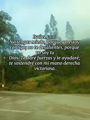 A photograph from a moving vehicle of a road, green grassy hill, and sky, with overlaid text. The road curves upward toward the left of the frame.  A grassy hill fills the lower portion of the image, leading toward a treeline filling the mid-ground. The blurred backdrop suggests a cloudy sky.  White text is superimposed over the scene, conveying a bible verse.