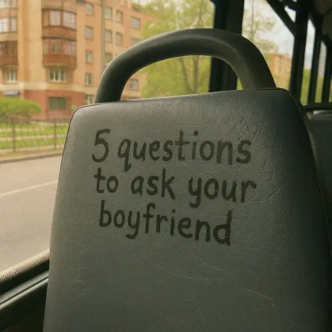 The image shows the back of a bus seat with text overlayed on it. The seat is gray, and the text is in a handwritten style. Behind the seat, through the bus window, is a blurry view of buildings and trees.