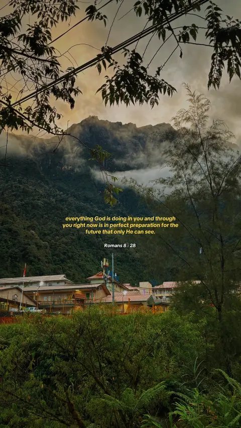 An image showcasing a scenic mountain landscape at dusk. The sky transitions from a golden hue to a darker shade, suggesting sunset or sunrise. A visible mountain range is partially obscured by clouds, enhancing a sense of mystery. The foreground features lush greenery, with buildings in the mid-ground, adding depth to the composition. Text is overlaid in a golden font, with a Bible reference at the bottom.