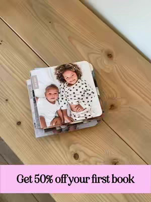 The cover image shows a stack of books on a wooden surface. The books have a photo of two children. Written on top are the words "Get 50% off your first book" in a pink rectangular box.