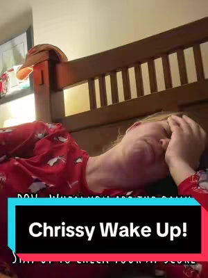 A person lies in bed with their head cradled in one hand, appearing weary. A text overlay in a colored box urges them to "Chrissy Wake Up!"