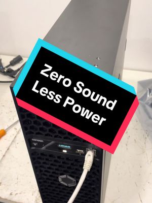 The image shows a dark-colored computer tower angled slightly to the right. A rectangular banner with the words 'Zero Sound Less Power' is overlaid diagonally across the top half. The tower has a mesh front, an ethernet cable is plugged in, and the top appears to have a few ports and buttons. The background is a plain, light surface.