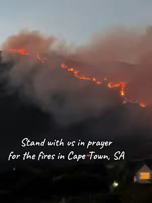 The cover image shows a nighttime landscape with a hillside ablaze with fire. Streaks of orange and red flames light up the dark sky and smoke. A white text, with a black background, appears at the bottom describing the situation and inviting viewers to join in prayer.