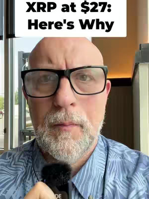 A man with glasses and a beard is holding a microphone and looking at the camera. A text box appears at the top of the frame.