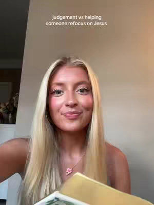 A woman with long blonde hair looks towards the camera with a slight smile. The text overlay reads, 'judgement vs helping someone refocus on Jesus'. She wears a necklace with a flower charm. The background appears to be a light-colored wall.