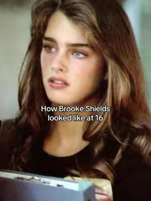 The image is a close-up shot of Brooke Shields from the 80s. She has long, layered brown hair, and is looking slightly off-camera with a wistful expression. The background is blurred.