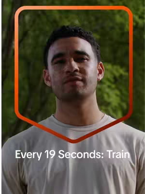 A selfie-style shot featuring a man in a light-colored t-shirt framed in front of a blurry green background. An orange-red border and hook text has been added.