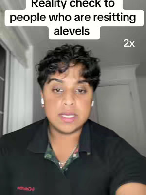 A person with dark curly hair and wearing a black shirt looks at the camera. Above their head, there is text overlay.