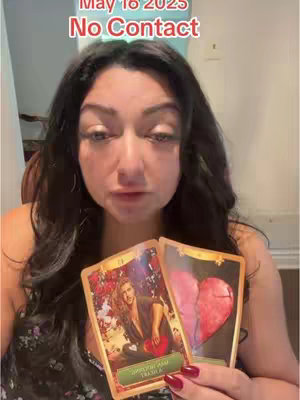 A woman with long dark hair is centered in the image, holding two tarot cards. The top text overlay reads "May 16 2025" on top of "No Contact" in red. The woman looks directly at the viewer with a serious expression. The tarot cards are brightly colored, with imagery related to relationships.