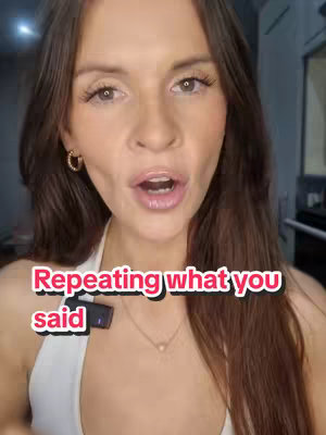 A woman with long brown hair and gold hoop earrings looks directly at the camera, with a microphone clipped to her shirt. Text overlay says 'Repeating what you said'. The background is slightly blurred, suggesting an indoor setting.