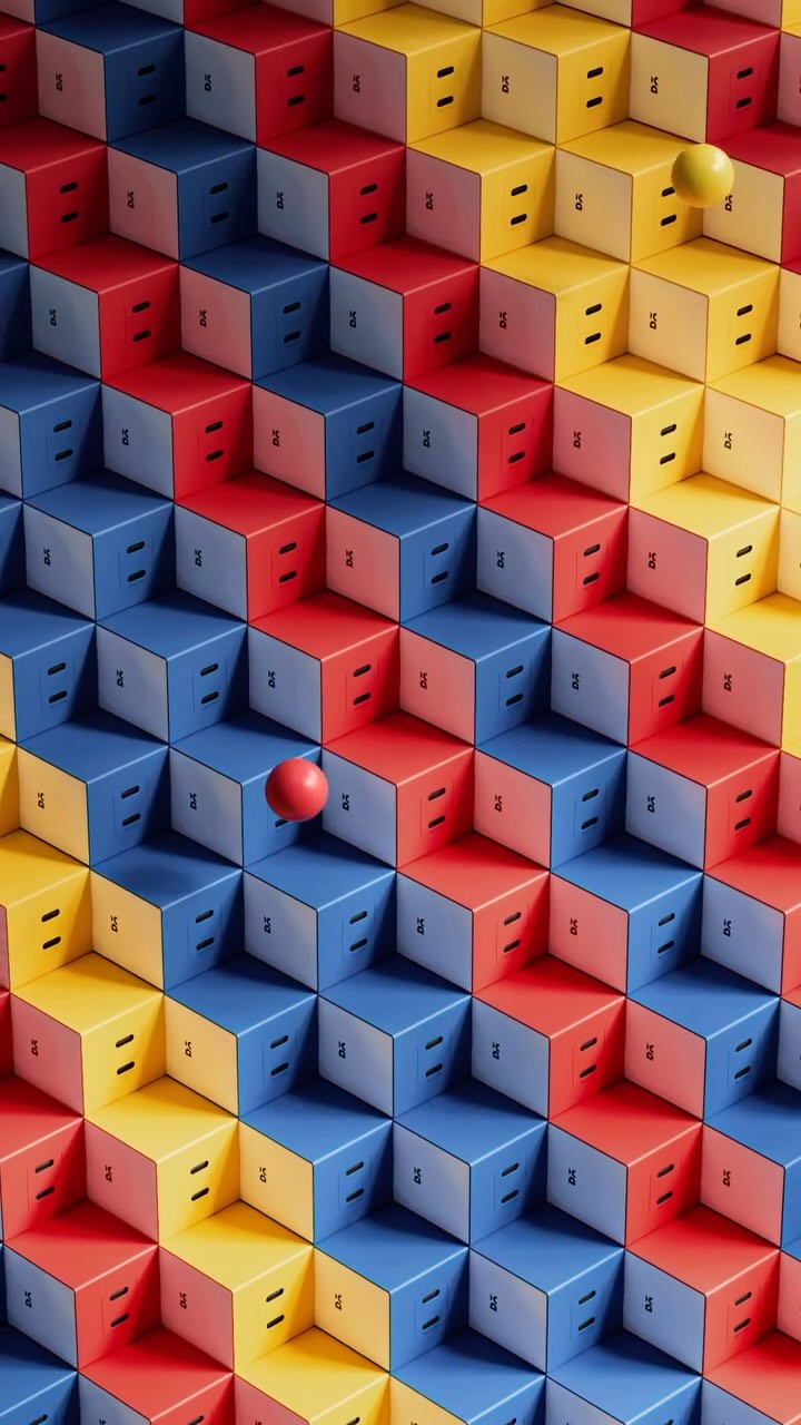 An abstract image features a grid of colorful boxes arranged in 3D steps. The boxes alternate between red, blue, and yellow, creating a checkerboard pattern. Each box has a small, dark opening on the front. Two spheres, one yellow and one red, float near the boxes, adding depth and visual interest.