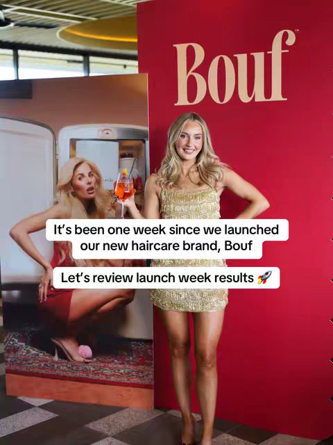 A woman in a gold dress stands in front of a red backdrop with the brand name "Bouf." To her left, a large picture is displayed. Overlay text declares "It's been one week since we launched our new haircare brand, Bouf. Let's review launch week results." The woman is smiling and holding a drink. 