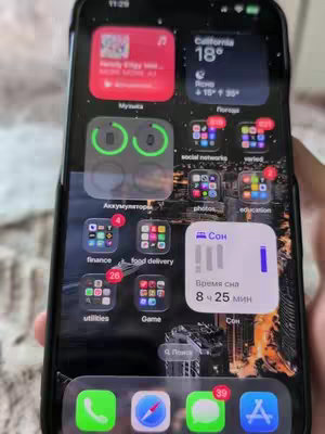 The cover image shows a close-up of an iPhone screen displaying various app icons, widgets, and notifications. The background is a cityscape at night. The phone is held in someone's hand, and the overall composition is focused on the screen's content.