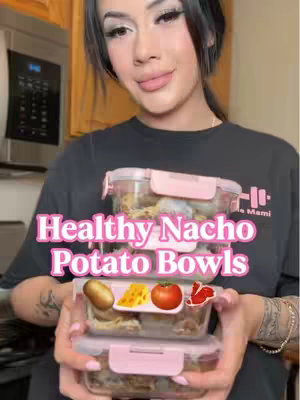 A woman with long black hair and makeup holds a set of clear food containers with pink lids, stacked on top of each other. The text overlay in the image reads 'Healthy Nacho Potato Bowls'. In the background, a kitchen is visible.