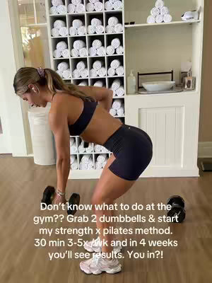 A woman in workout attire is bent over with dumbbells in a gym setting. She's mid-exercise, with part of her back and glutes emphasized. The background includes shelves of neatly rolled white towels. Text overlays suggest a workout plan.
