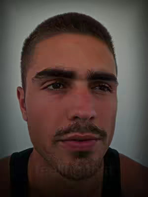 A close-up shot of a young man's face. He has short brown hair, thick, dark eyebrows, and a neatly trimmed mustache and goatee. The background is a gradient of gray. He is wearing a black tank top and looking slightly off-center.