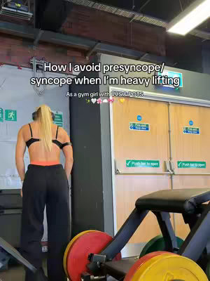 The cover image shows a woman from the back in a gym setting, dressed in sports attire, with text overlays. She's wearing a black sports bra and black pants with orange accents, and her blonde hair is in a ponytail, suggesting she's about to lift weights. Gym equipment is visible in the background.