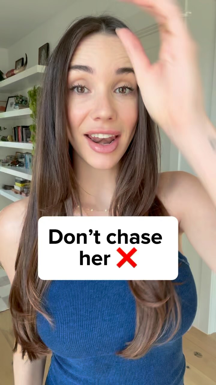 A woman with long brown hair smiles while looking at the camera. A white rectangle with the text "Don't chase her X" covers the lower part of her face.