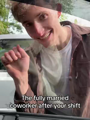 A young man with light skin, light brown hair, and a friendly expression is seen smiling while looking into the camera. The image is taken from an angle looking up through what appears to be a car window. The man is wearing a white t-shirt under a brown button-down shirt. Overlayed on the image is text describing a specific type of coworker and placed across the bottom.