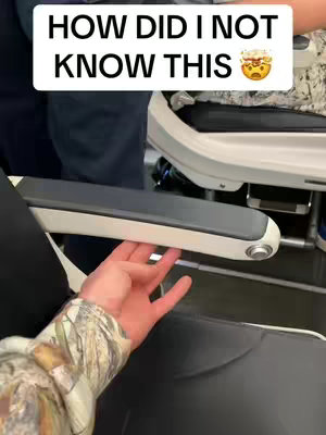 The image shows a person's hand adjusting an airplane armrest, with text overlaid indicating a life hack.