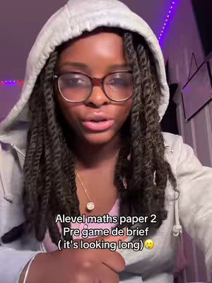 A young woman with dark hair and glasses, wearing a grey hooded sweatshirt, looks directly at the camera while speaking. Text overlays at the bottom of the frame.
