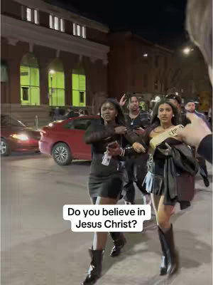Two women walking in front of a building at night with a text overlay that asks: "Do you believe in Jesus Christ?"