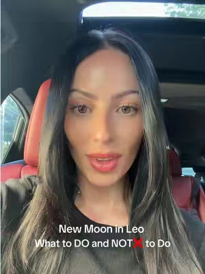 A woman with long dark hair and fair skin is in a car. She is looking directly at the camera and talking, red seats are in the background as well behind her. The on-screen text reads, "New moon in Leo, What to DO and NOT to Do".