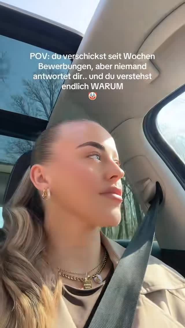A woman is seen from the side, looking out of a car window. She has blonde hair pulled back, wearing large hoop earrings and a necklace. Text overlaid on the image poses a question regarding job applications.