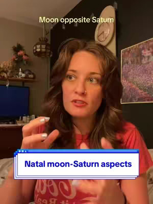 A woman with long brown hair is centered in the frame, gesturing with her hands as she speaks. Behind her is a room with a neutral color scheme, a clock, and a painting. The overlay includes a colored box highlighting the phrase 'Natal moon-Saturn aspects'.