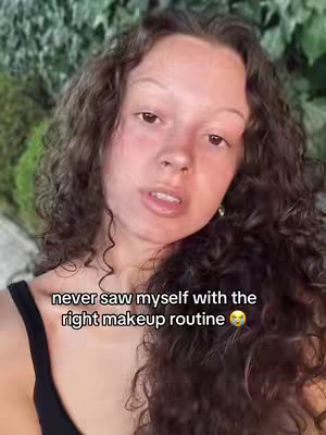 A selfie-style shot features a young woman with curly brown hair looking towards the camera. Text overlayed on the image reads: 'never saw myself with the right makeup routine'. The background is blurred, but appears to be outdoors with green foliage.
