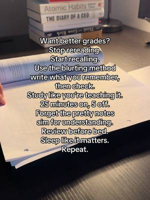 The image features a desk setup with a stack of books, a writing pad, and a hand holding the pad. Text overlays are present over the image, giving study tips, the image has a natural lighting.