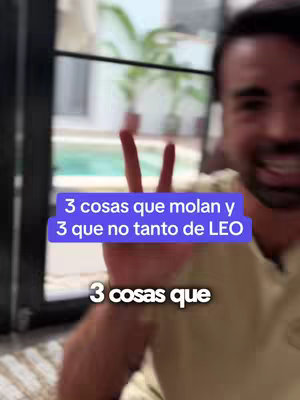 A man is shown smiling at the viewer while holding up a peace sign with his hand. Overlayed on the image are blue and white text boxes, and visible in the background is a view of an outdoor area with plants and possibly a pool.